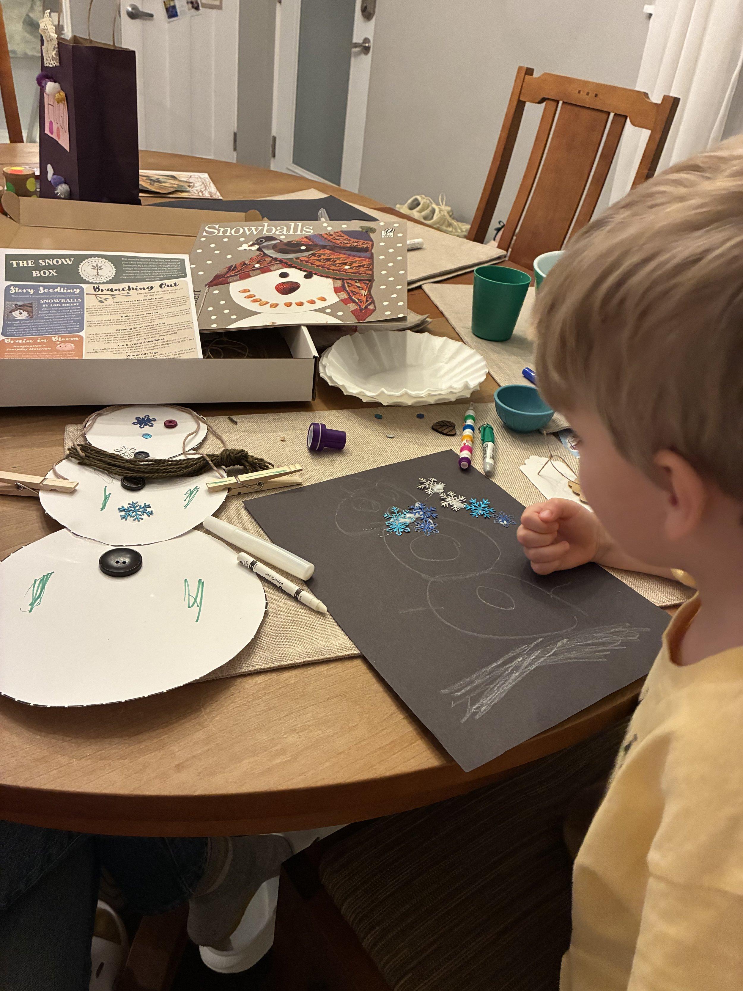 A child using hands-on materials from a Rooted in Writing box at home