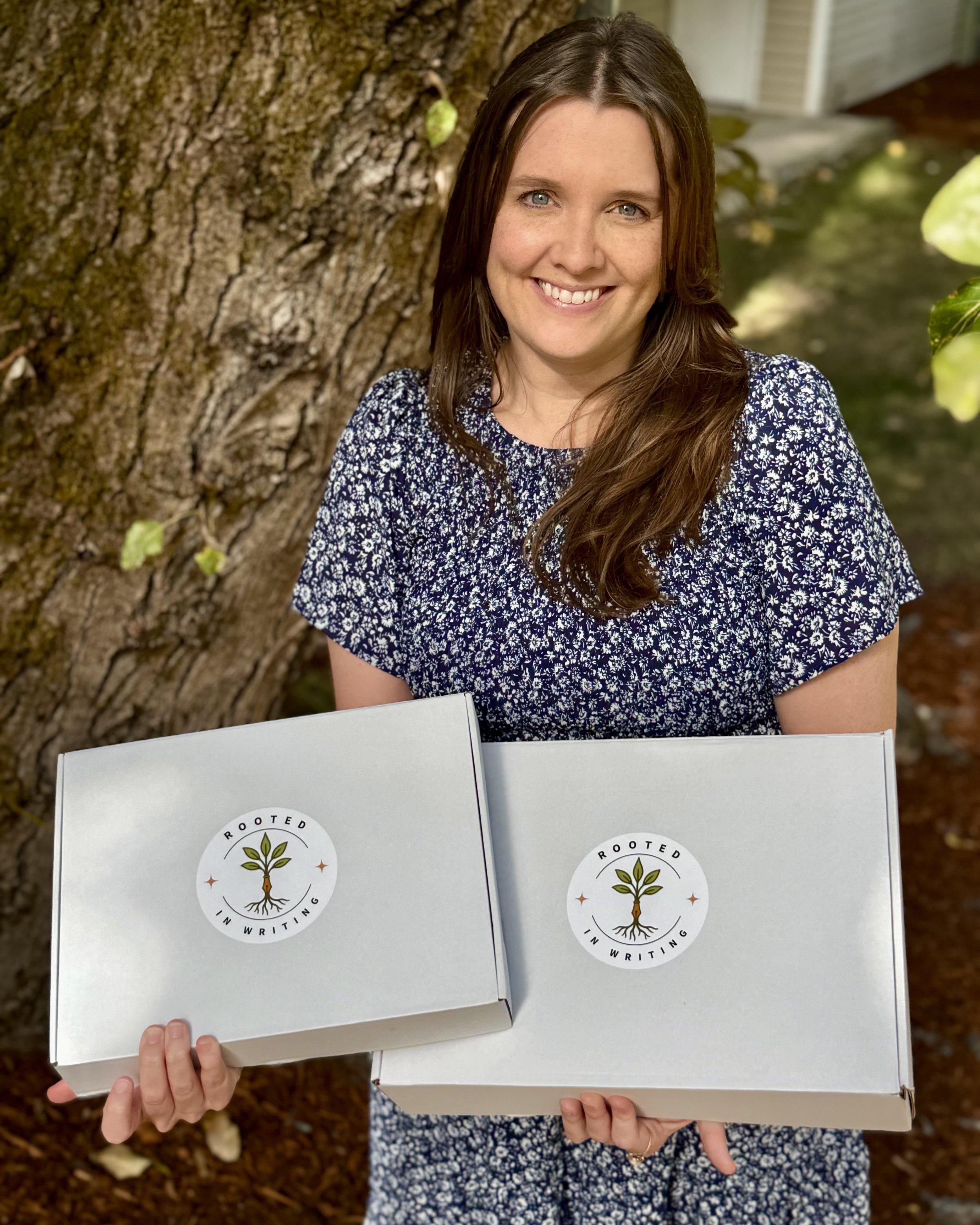 Erin Moffet, founder of Rooted in Writing, holding two boxes